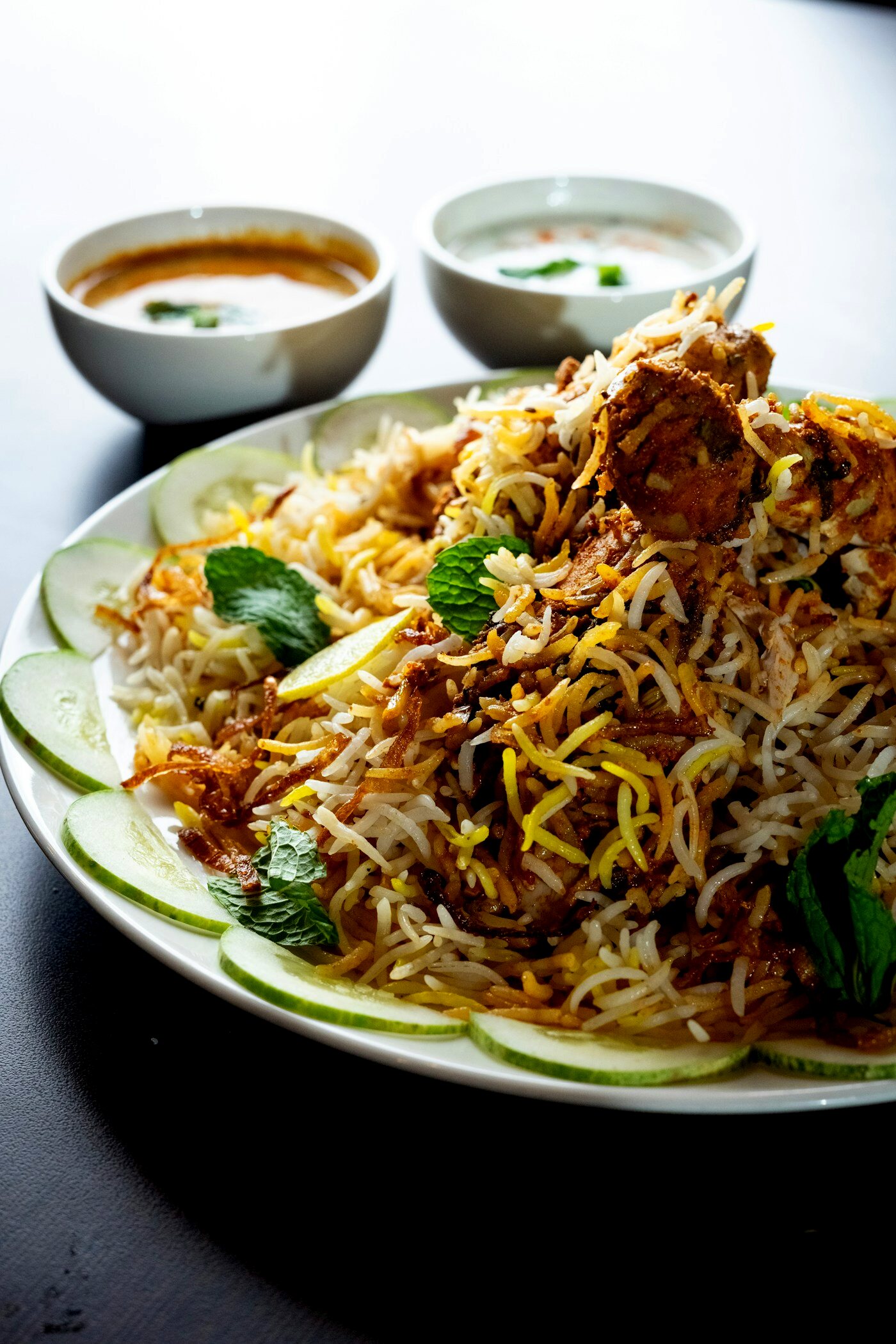 Biryani served with Mirchi Ka Salan and Dahi Raita